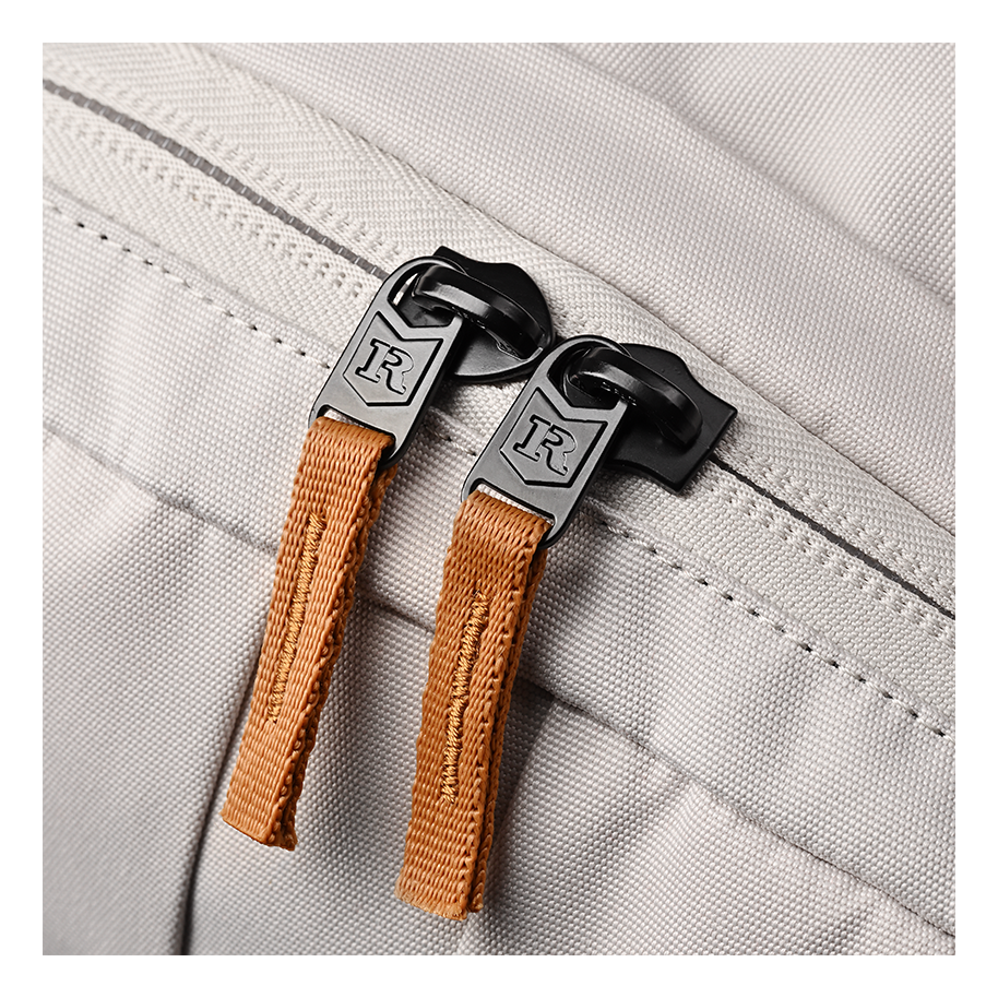 Ritual Covert hockey backpack white with brown handles and black zippers, closeup view